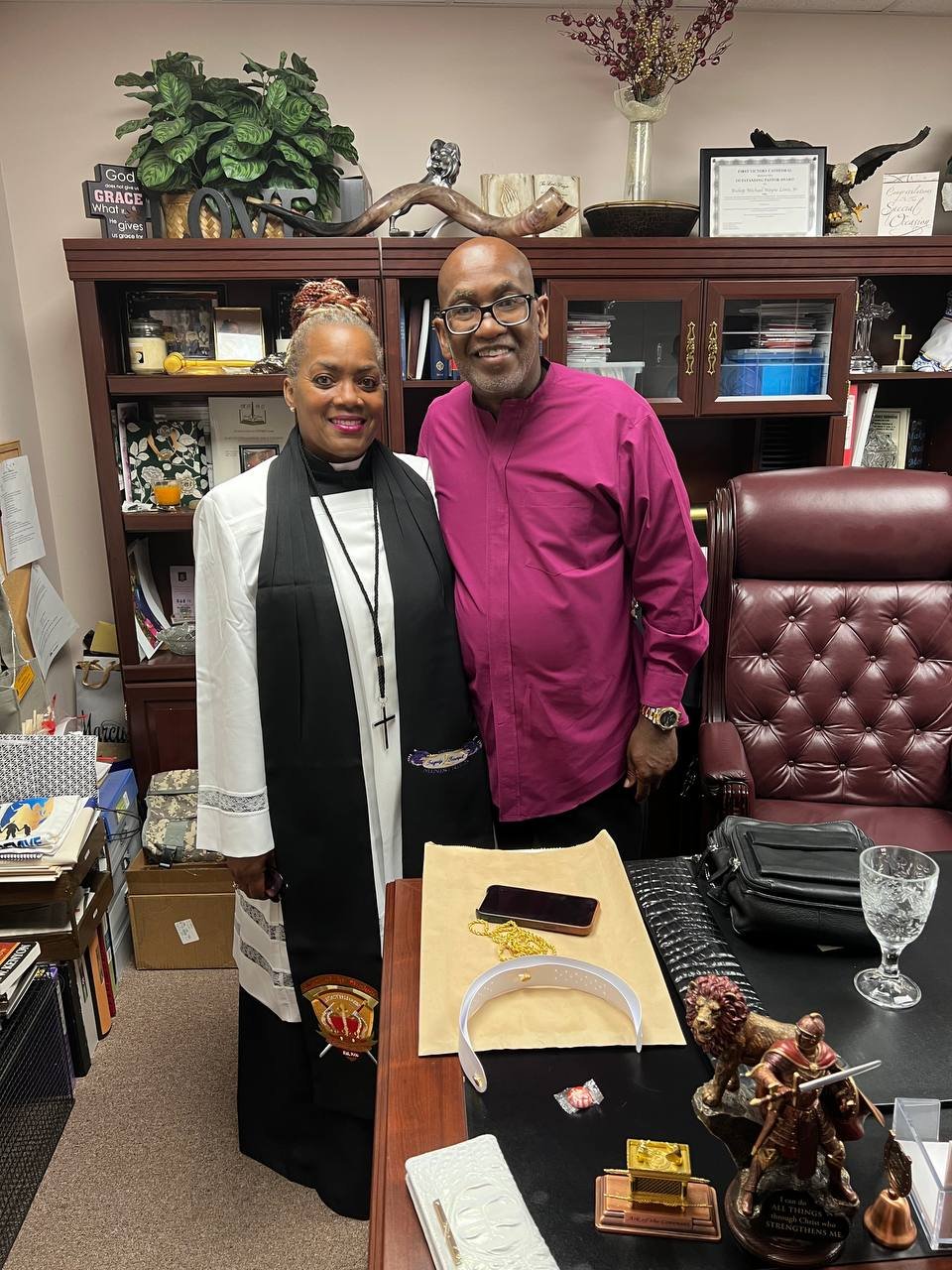 A minister standing with a colleague in an office