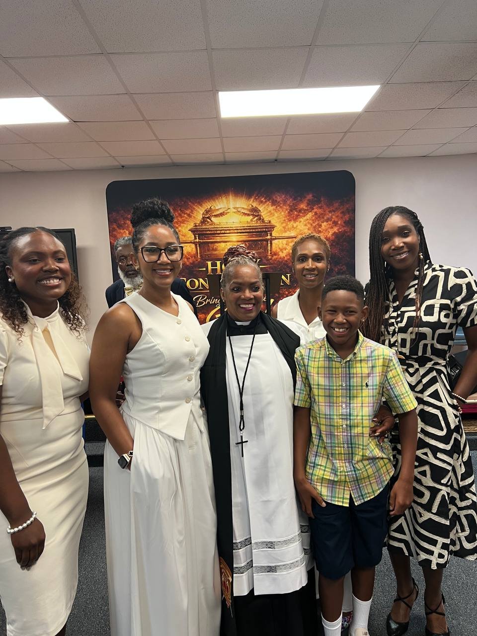 A minister standing with family and community members