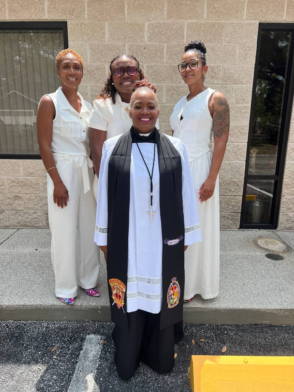 A minister standing with women and a child after a service